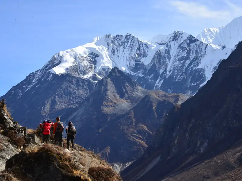Wanderer auf einem Bergpfad mit Blick auf die schneebedeckten Gipfel des Himalayas.