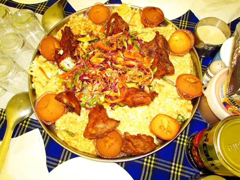 Gebratenes Hühnchen mit Salat und Beilagen auf einer Platte.