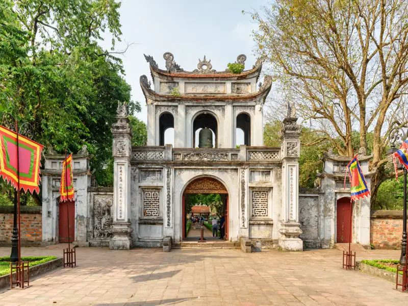 Eingangstor eines Tempels mit Fahnen und traditionellen Verzierungen.