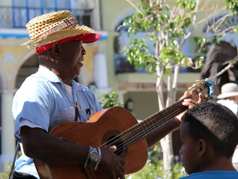 Straßenmusiker spielt Gitarre auf einer Plaza.