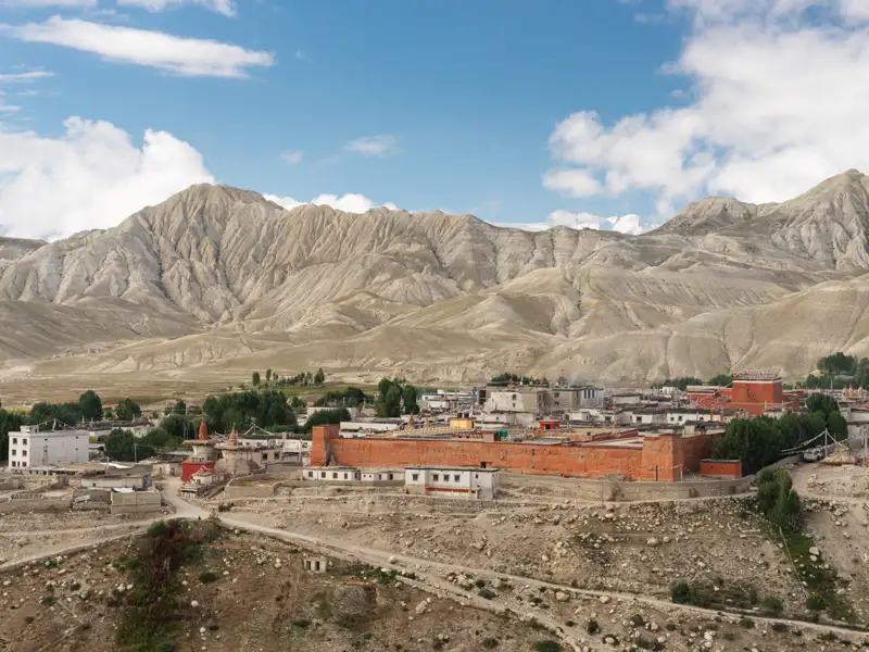Traditionelle Siedlung im tibetischen Hochland mit Blick auf die umliegenden Berge.