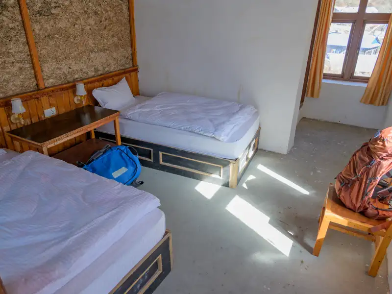 Zimmer mit zwei Betten und Rucksäcken, vorbereitet für die Reise.