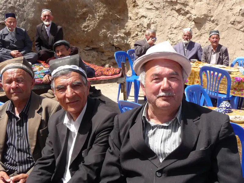 Einheimische Männer in traditioneller Kleidung treffen sich im Freien.