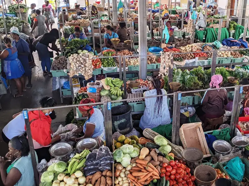 Händler verkaufen frisches Obst und Gemüse auf einem belebten Markt.