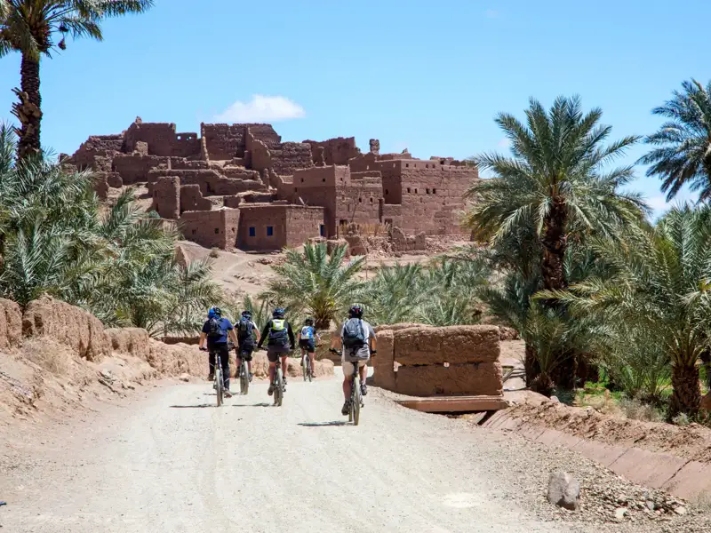 Mountainbiker auf dem Weg zu einer historischen Lehmbausiedlung.