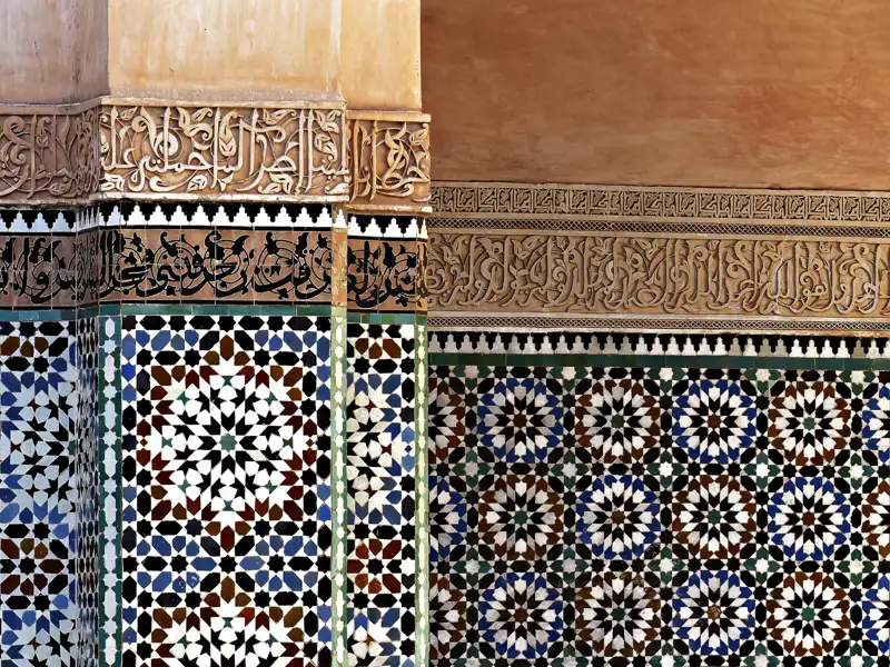 Detailansicht der kunstvollen Mosaikfliesen und der arabischen Kalligrafie, die die Wände schmücken.