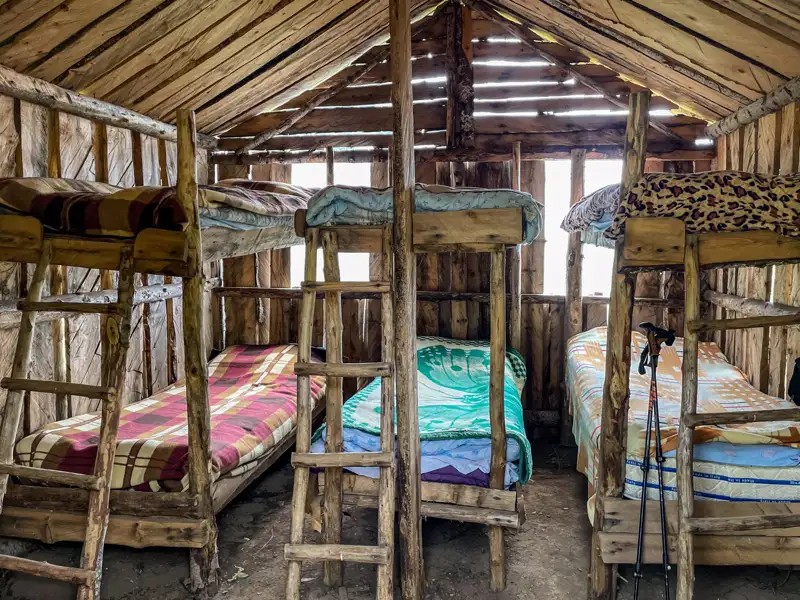 Stockbetten in einer einfachen Holzhütte, bereit für müde Wanderer.