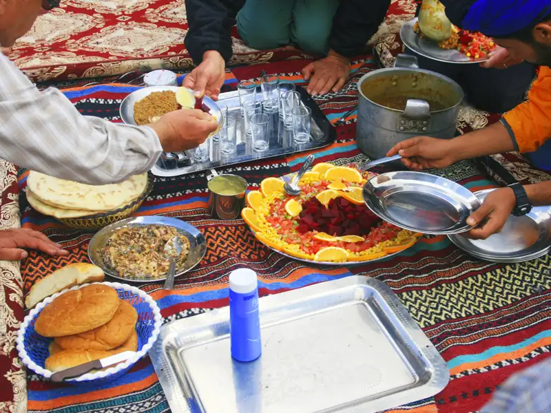 Traditionelle Reiseverpflegung mit Fladenbrot, Salat und Eintopf.