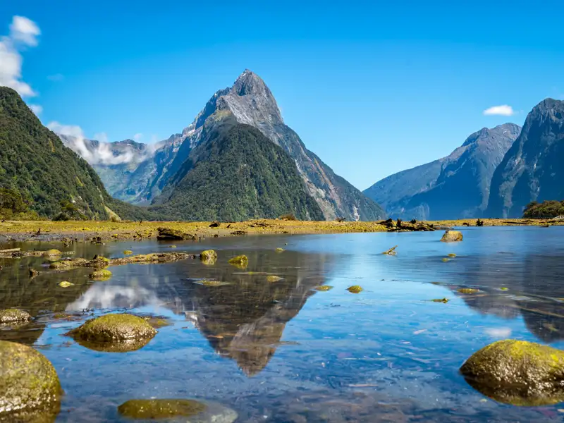 Spektakuläre Berglandschaft am Milford Sound mit klarer Spiegelung im Wasser.