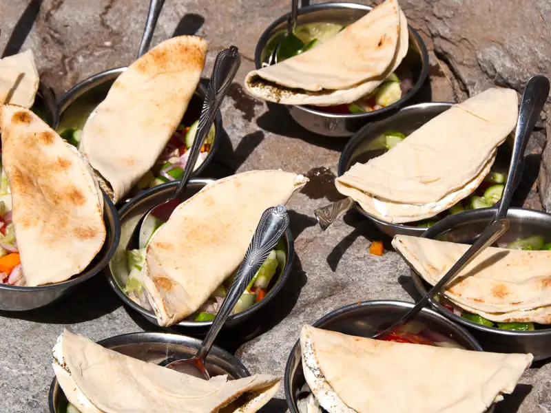 Fladenbrot und Salat in Schalen.