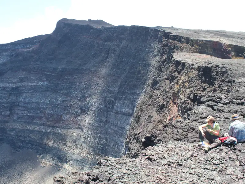 Zwei Personen betrachten den Vulkankrater.