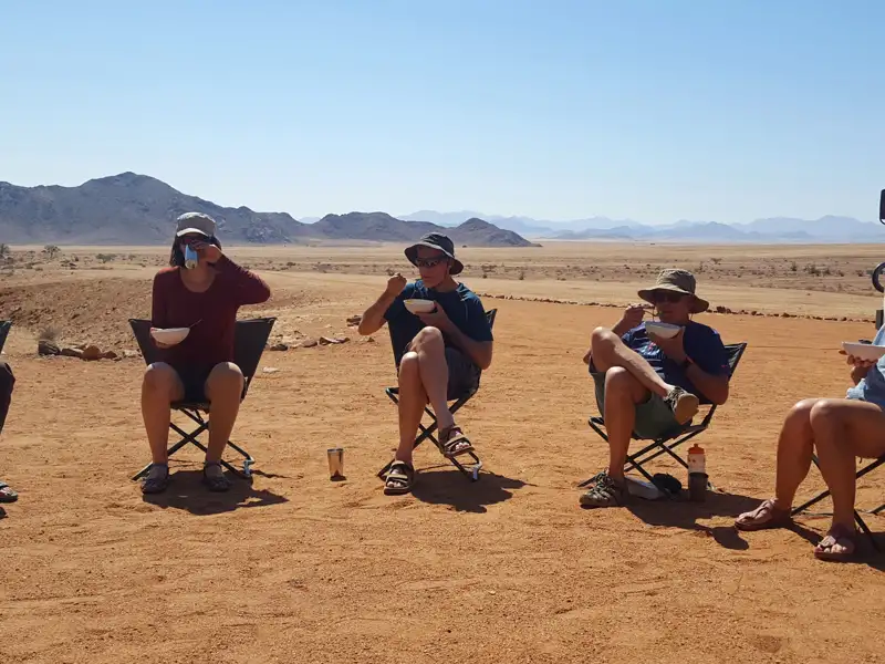 Reisende machen eine Pause und essen während ihrer Reise durch die Wüste.