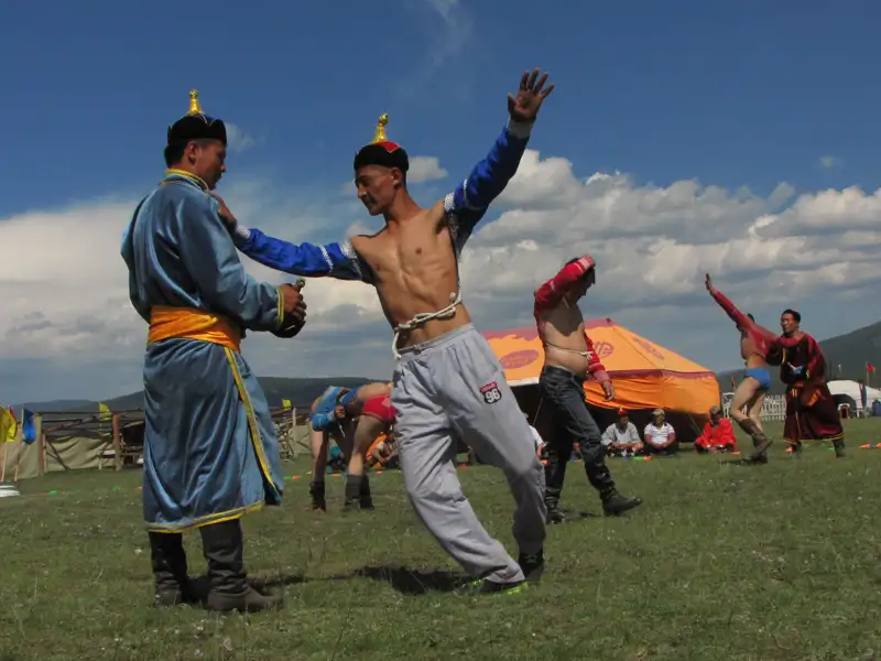 Mongolische Ringer demonstrieren ihre Fähigkeiten und Techniken während eines traditionellen Ringkampfes.
