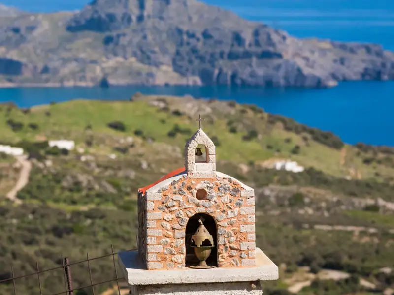 Kleine Kapelle an der Küste mit Blick auf das Meer und die Berge.
