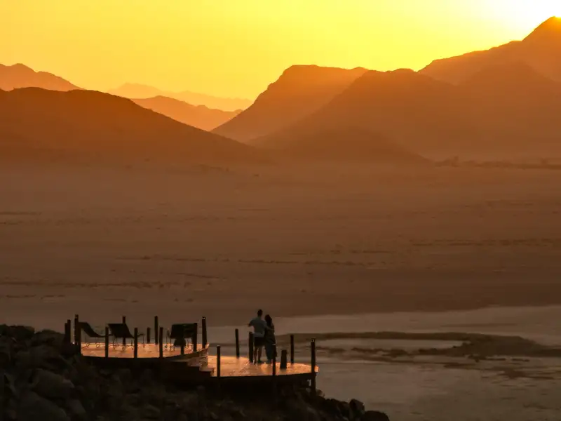 Aussichtsplattform mit Blick auf den Sonnenuntergang über der Wüste.