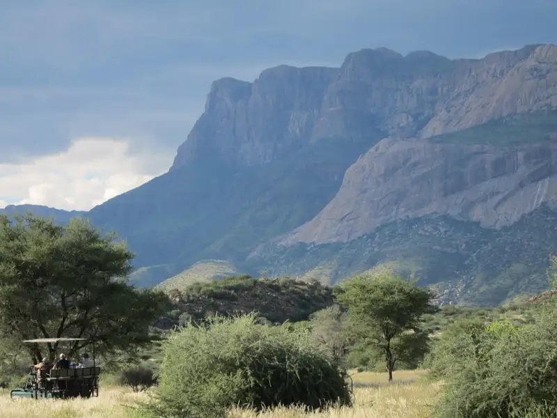 Safari-Gäste beobachten die Berglandschaft vom Fahrzeug aus.