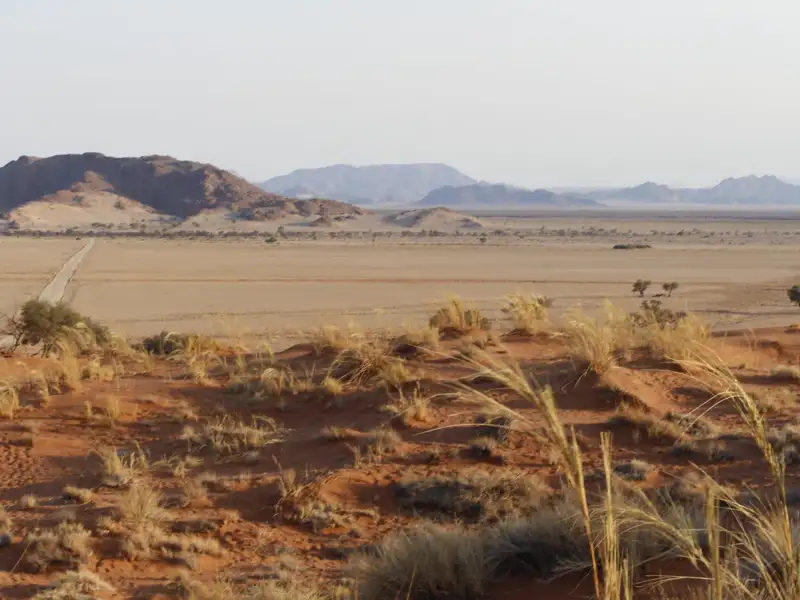 Wüstenlandschaft mit Straße, Ebene und Bergen.