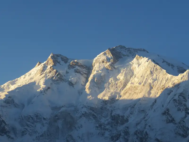 Verschneite Bergspitzen im Sonnenlicht.