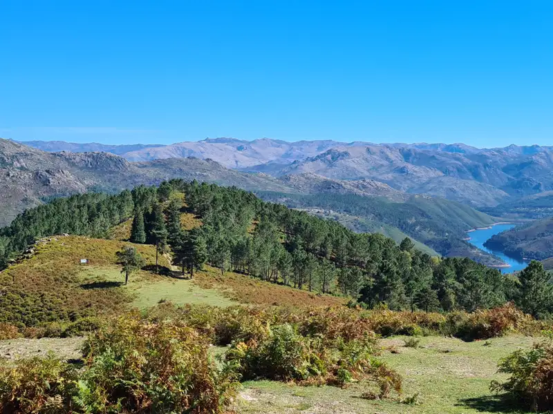 Ausblick auf die Berglandschaft mit bewaldeten Hügeln und einem Stausee.