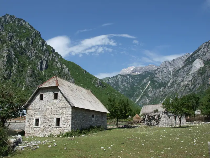 Steinhaus in einer bergigen Landschaft.
