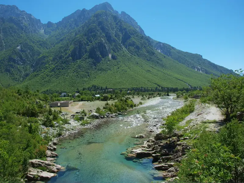 Klares Flusswasser fließt durch eine Berglandschaft.