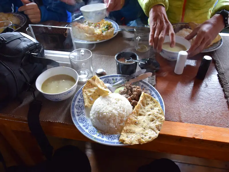 Eine typische Mahlzeit während der Reise, bestehend aus Reis, Fleisch, Fladenbrot und Suppe.