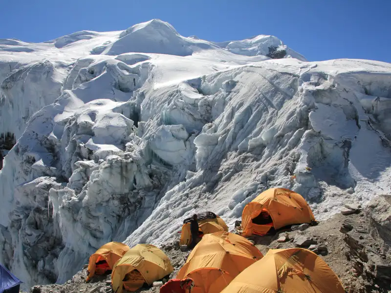 Basislager mit Zelten am Fuß eines Gletschers.