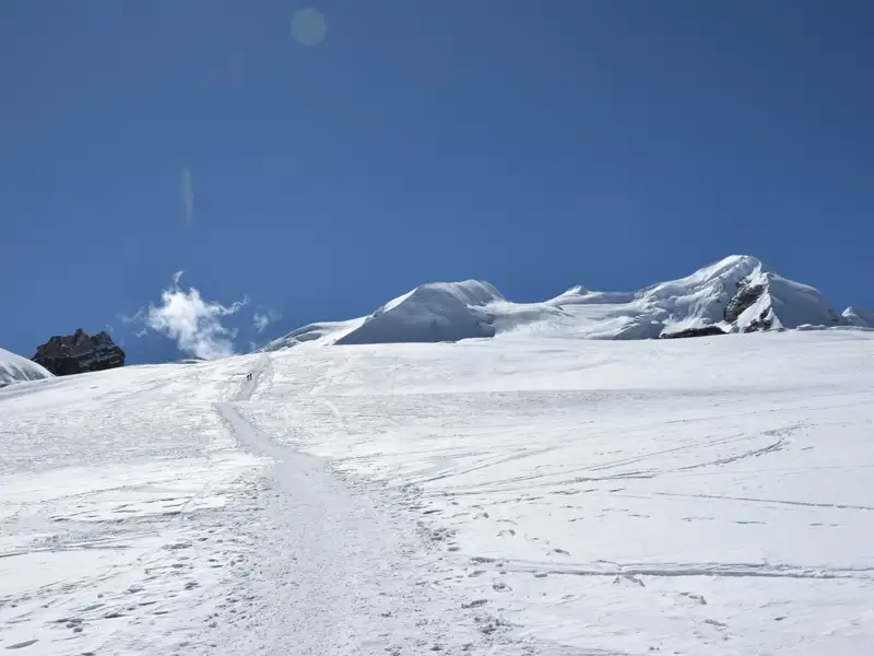 Verschneiter Hang und Berggipfel