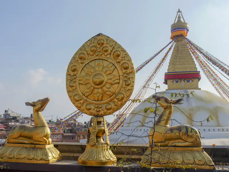 Goldene Hirschstatuen und Dharma-Rad vor der Boudhanath Stupa in Nepal.