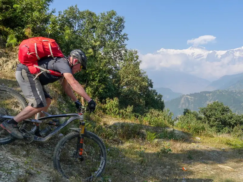 Mountainbiker auf einem Bergpfad mit Blick auf die Berglandschaft.