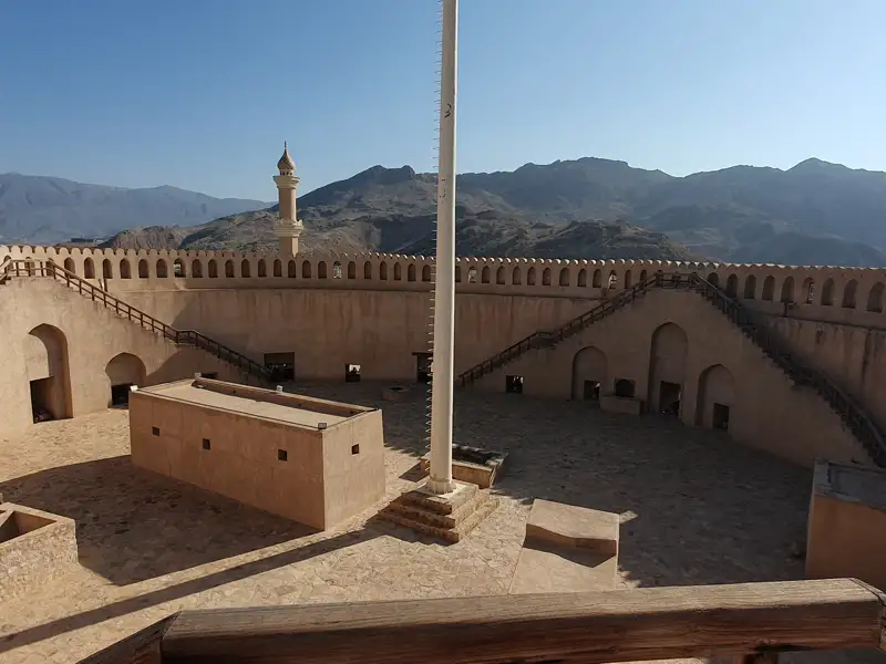 Innenansicht einer Festung mit architektonischen Details und Berglandschaft.