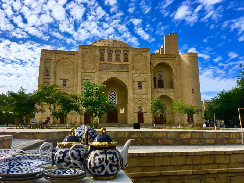 Traditionelle Teekannen und Geschirr vor einem historischen Gebäude.