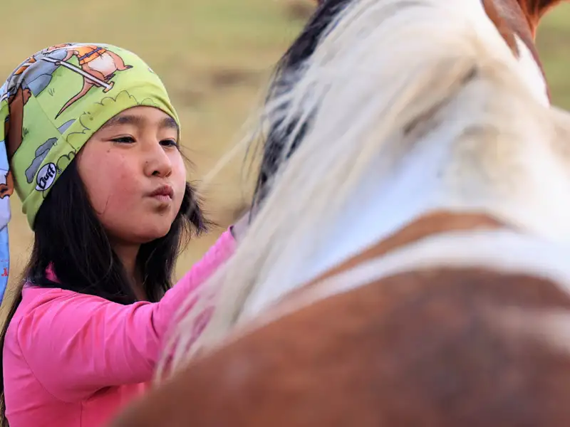 Mädchen neben einem Pferd.