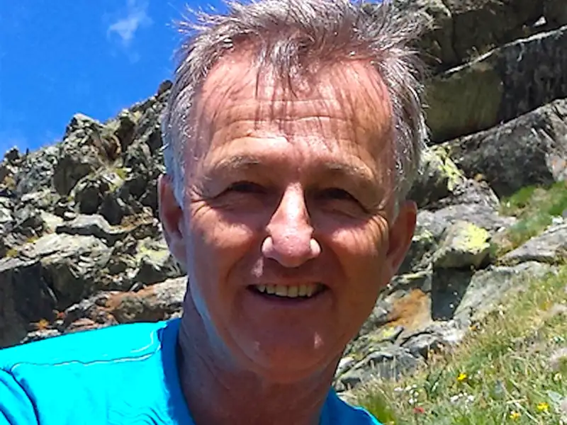 Reisender auf einer Bergwanderung, posiert vor einem felsigen Hintergrund.