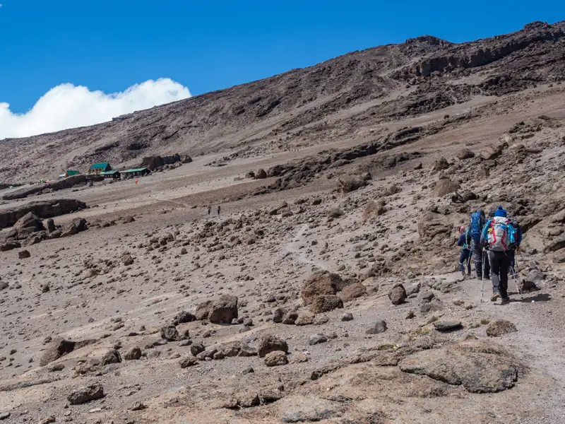 Wanderer auf dem Weg zu einer Berghütte in den Bergen.