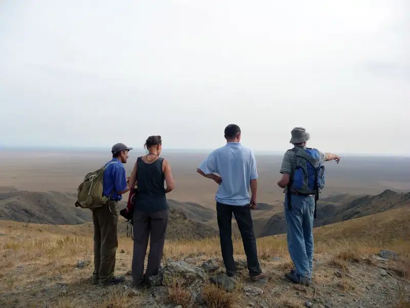 Wanderer mit Rucksäcken beobachten die weite Landschaft während ihrer Reise.