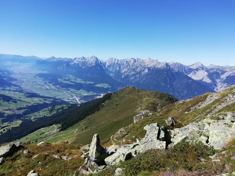 Wanderweg mit Blick auf das Tal und die umliegenden Berge.