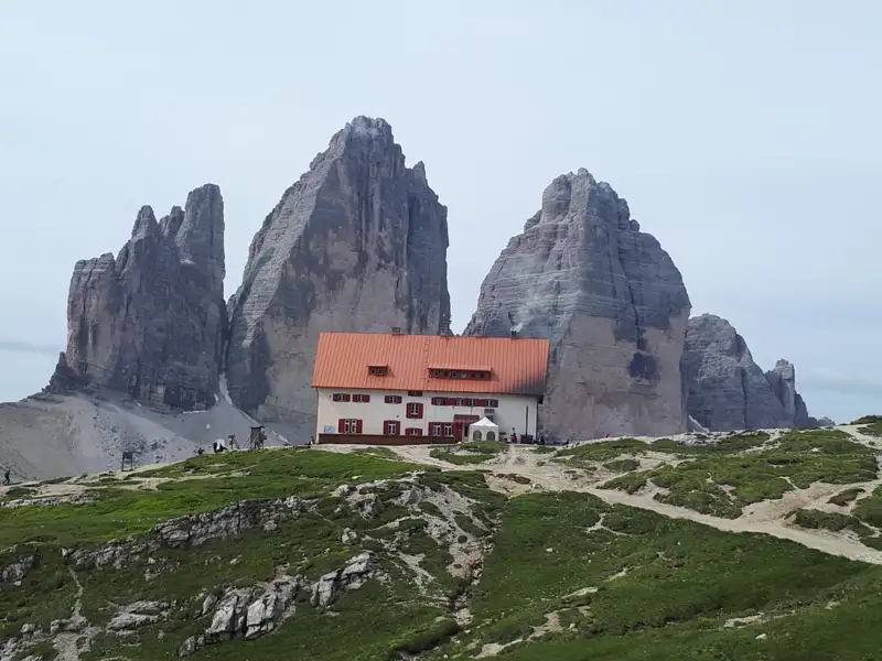 Eine Berghütte am Fuße der markanten Felsformationen.