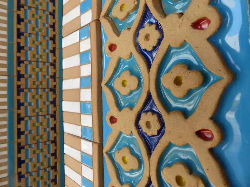 Nahaufnahme der Keramikfliesen mit blauen, roten, gelben und weißen Details.