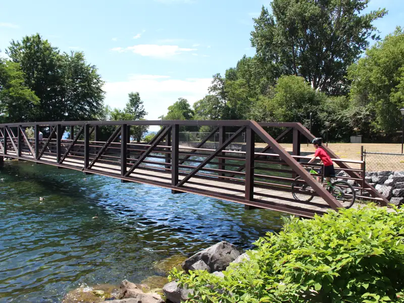 Radfahrer überquert eine Brücke über einen Fluss.