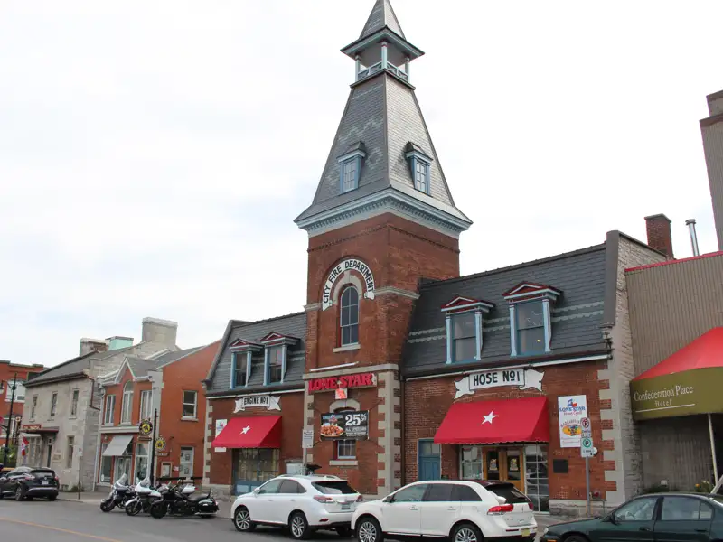 Altes Feuerwehrhaus mit Aufschrift 'City Fire Department', jetzt umgebaut für Geschäfte.
