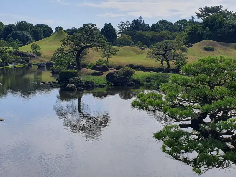 Teich und Bäume in einem japanischen Garten.