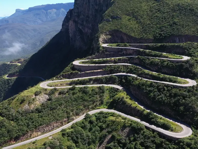 Serpentinenstraße in bergigem Gelände.