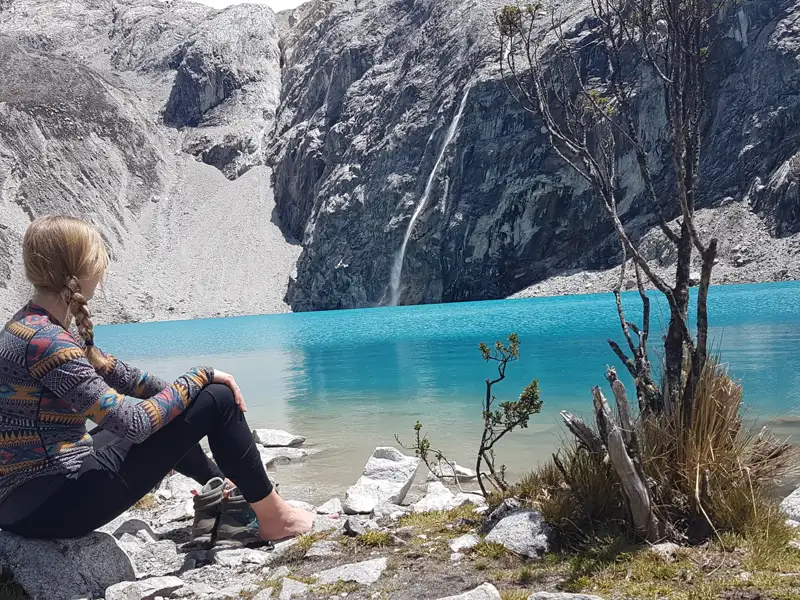 Reisende am Ufer eines türkisfarbenen Bergsees in den Bergen.