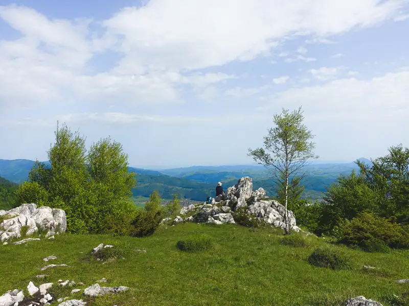 Blick von einem Berggipfel auf die umliegende Landschaft.