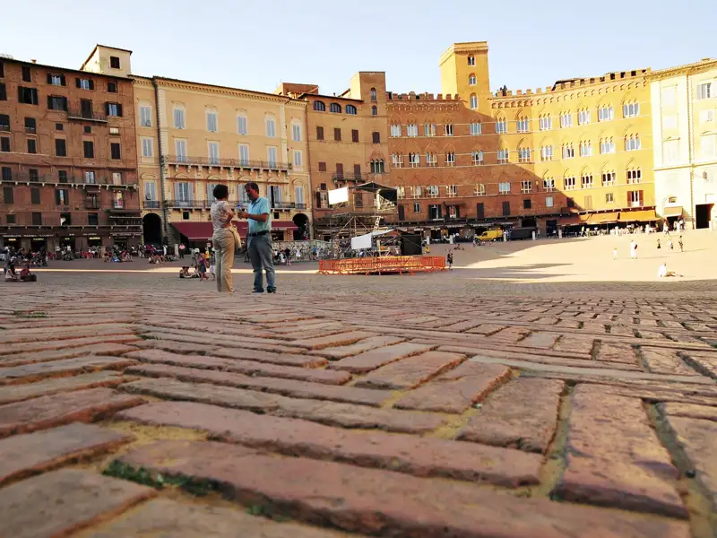Gepflasterter Piazza del Campo in Siena mit umliegenden historischen Gebäuden.