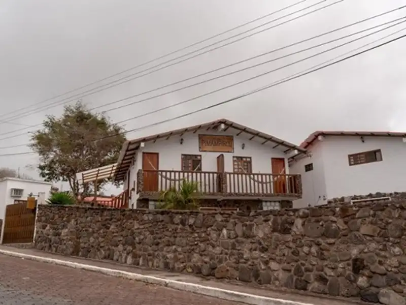 Außenansicht des Gästehauses mit Steinmauer und Balkon.