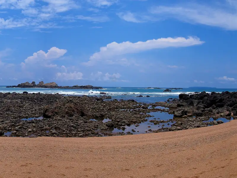 Felsige Küstenlandschaft mit Blick auf das Meer und Inseln.