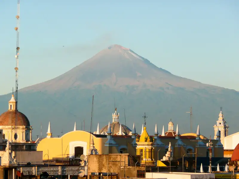 Vulkan über den Dächern einer Stadt.
