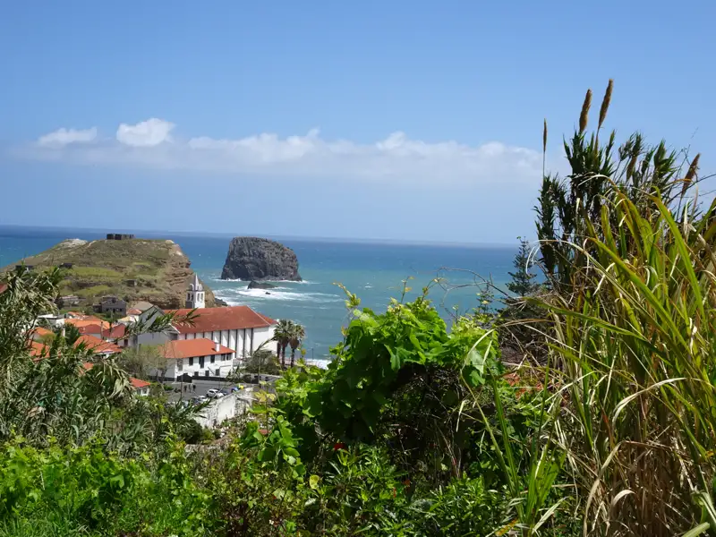 Blick auf die Küste mit Stadt, Kirche und Felsen im Meer.